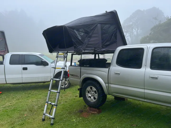 Truck with iKamper rooftop tent, ladder in foggy campsite. Great for outdoor camping & an RV rental option.. Rv Camper Tacoma 2002