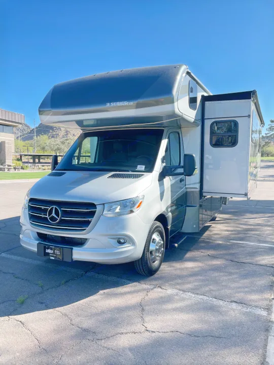 This silver Mercedes-Benz Sprinter 3 Series Class C RV rental, with its slide-out extended, is ready for adventure.. Forest River Dynamax Isata 3 24FW 2023
