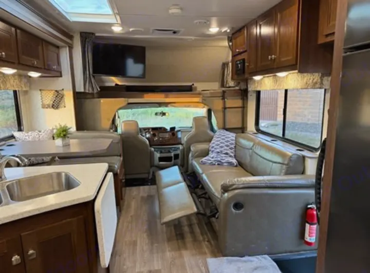Spacious RV rental interior with a kitchen, dinette, reclined sofa, and front cabin view, perfect for travel.. Forest River 3051S Ford 2017