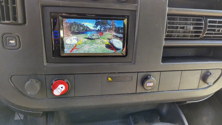 RV rental dashboard with backup camera displaying a campsite, battery switch, and USB charger.. Chevrolet Express 2009