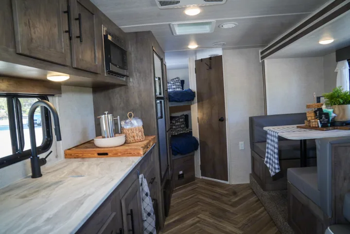 Spacious RV rental interior with a modern kitchen, cozy dining booth, and convenient bunk beds for comfortable travel.. Forest River EVO 2021