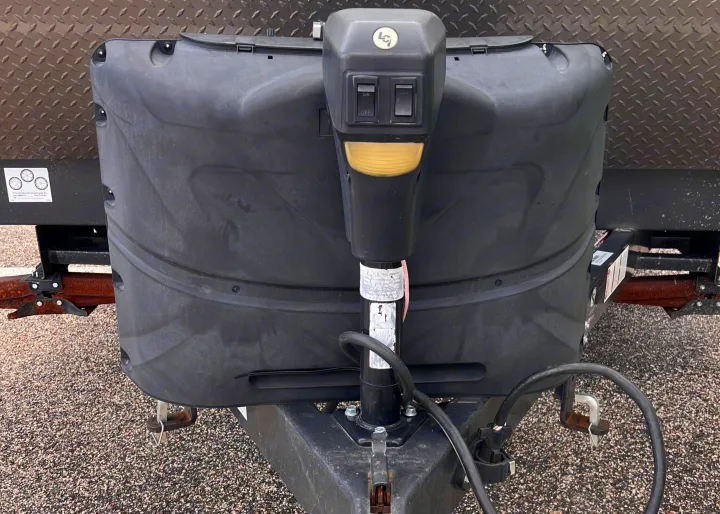 Close-up of an RV rental's front section, featuring the electric power jack and black cover over propane tanks for towing.. Forest River Solaire 2020
