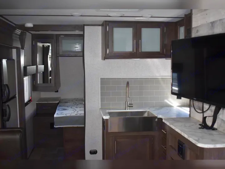 Tour this RV rental's modern interior: well-equipped kitchen, comfortable living space with TV, and private bedroom.. Dutchmen Coleman Light 2021