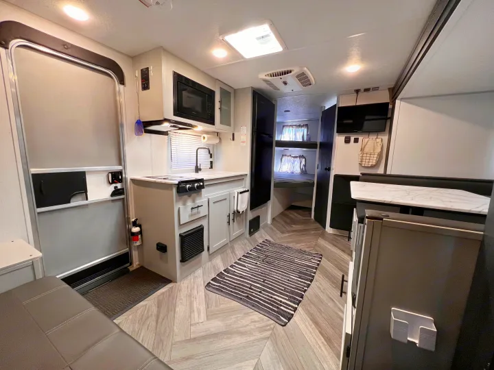 Spacious, modern RV rental interior featuring a full kitchen, dining area, and cozy bunk beds. Ideal for travel adventures.. Wildwood FSX 2021