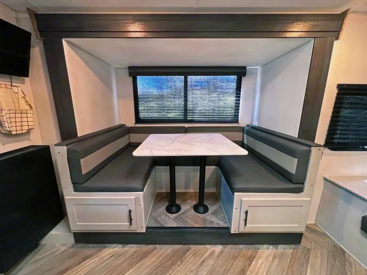RV rental: Bright, modern dinette with U-shaped gray and white booth seating, a marble-look table, and dark accent trim.. Wildwood FSX 2021