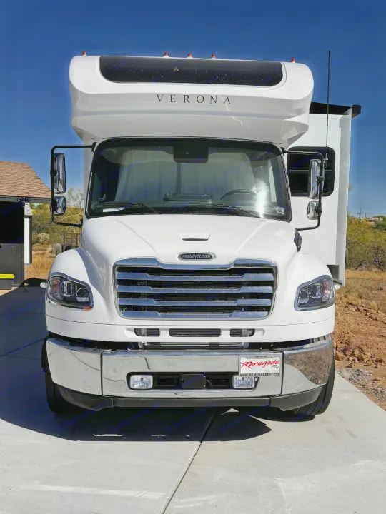 White Freightliner Verona RV rental, a luxurious motorhome, parked outdoors on a sunny day, ready for travel.. Renegade Verona 40 VRB 2024