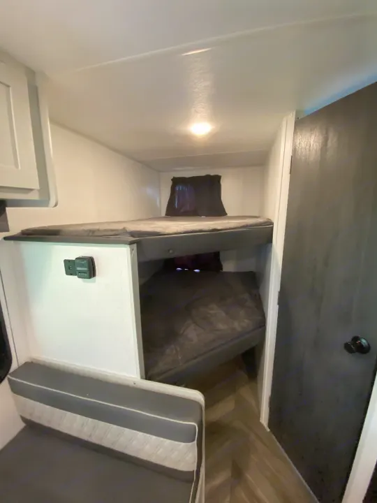 Compact RV rental bunk beds and bench seating, with controls, for a comfortable and efficient mobile adventure.. Forest River Salem FSX Plantium 2022
