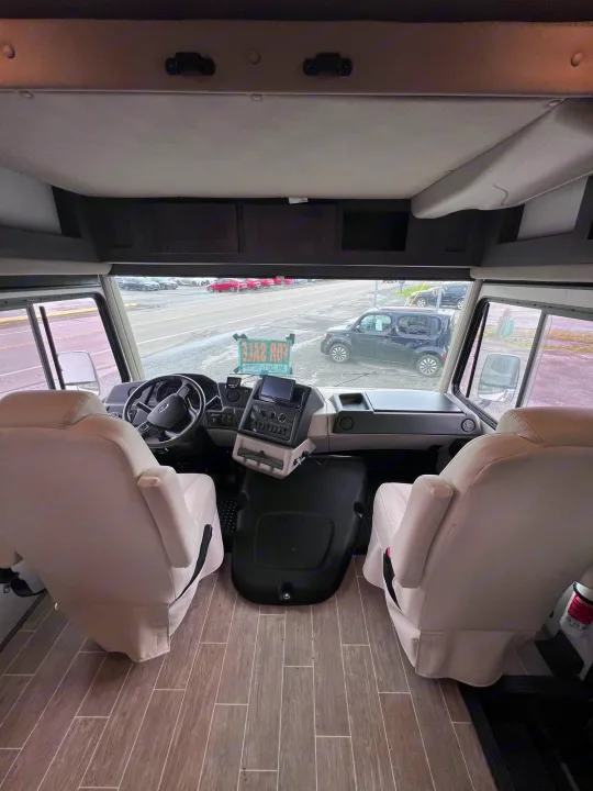Interior of an RV rental: Looking forward at the spacious cockpit, featuring comfortable front seats, dashboard, and large windshield.. Forest River Georgetown 2022