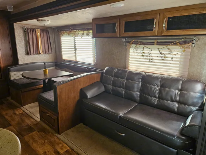 Comfortable RV rental interior featuring a dinette, plush sofa, and cabinets. Ideal for road trip adventures!. Forest River Salem 2017