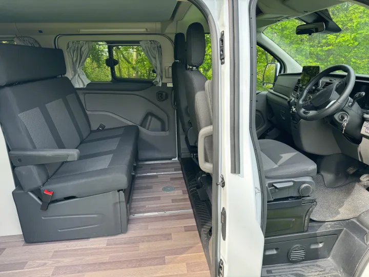 Interior of an RV rental camper van, showing spacious front and rear seats, ideal for comfortable travel.. Ford Nugget 2022