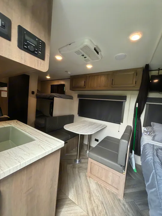 Compact RV rental interior featuring a kitchen, dinette, bunk beds, and sleeping area, perfect for travel.. Olympia Sport 19BH 2022