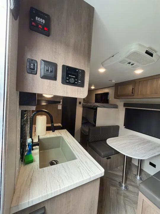 Modern RV rental interior with kitchen, dinette, and bunk beds.. Olympia Sport 19BH 2022