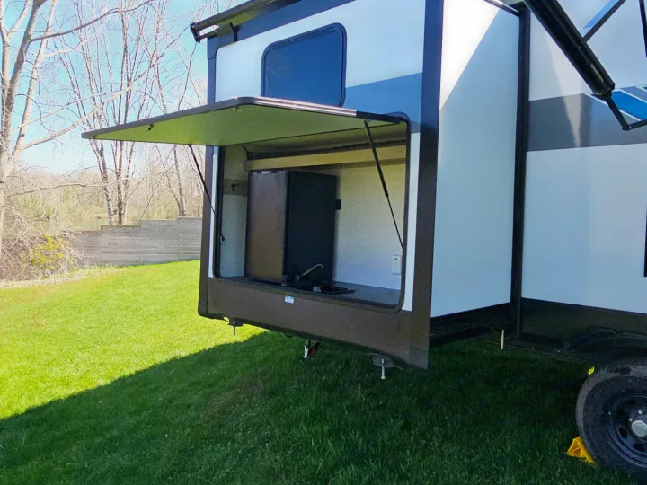 Enjoy the convenience of this RV rental's outdoor kitchen, complete with a fridge and counter space for your camping adventures.. Forest River Salem Platinum 2023