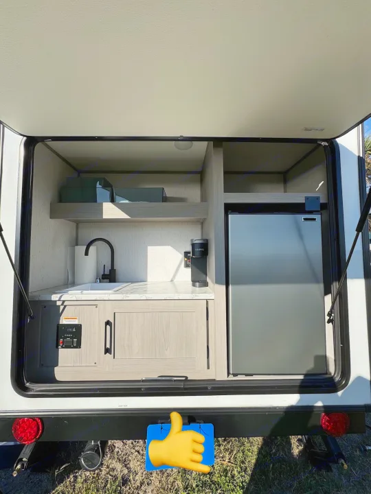 RV rental: Outdoor kitchen with sink, fridge, Keurig, shelves, and controls. Perfect for camp convenience.. Dutchmen Other 2023