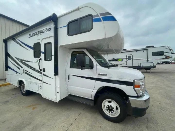 Bright white Class C Sunseeker RV for rv rental, with blue & black graphics, parked on a concrete lot.. Forest River Sunseeker LE 2021
