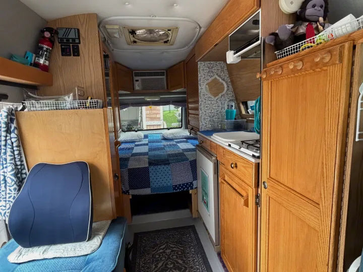 A well-appointed rv rental interior showcasing a cozy bedroom, compact kitchen, and clever storage solutions for comfortable travel.. Roadtrek 190 Popular 1997