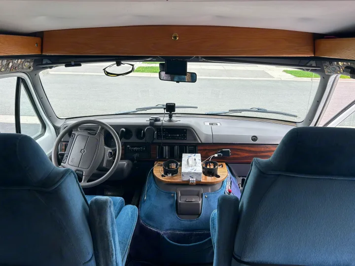 Spacious RV rental interior featuring blue seats, a detailed dashboard, and convenient console for comfortable travels.. Roadtrek 190 Popular 1997