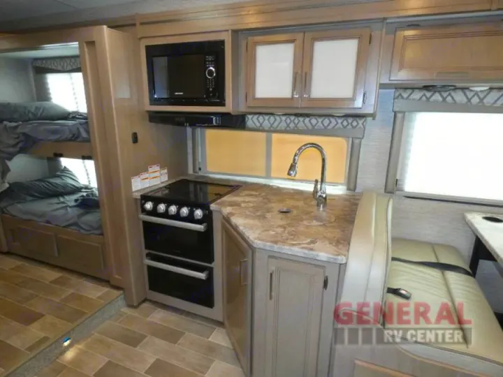 Spacious RV rental interior. Features include bunk beds, full kitchen with microwave, and comfortable dinette seating.. Thor Quantum SE 2022