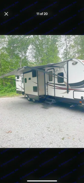RV rental: White travel trailer with awning extended, parked on gravel at a campsite.. Heartland RVs Sundance XLT 2016
