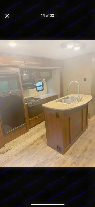 RV rental: Clean, modern kitchen with dark wood cabinets, all appliances, and island with sink.. Heartland RVs Sundance XLT 2016