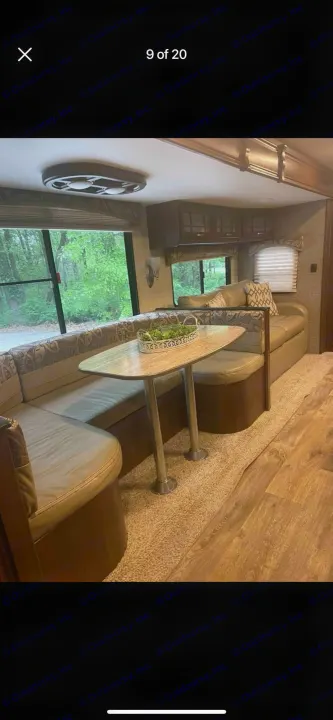 Spacious RV rental interior featuring a U-shaped dinette with seating, large windows, and overhead cabinets.. Heartland RVs Sundance XLT 2016