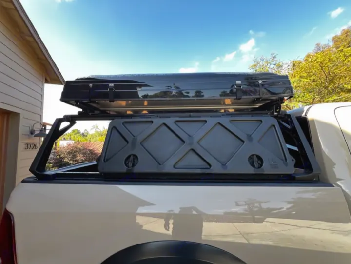 A beige pickup truck, fitted with a black bed rack and rooftop tent. Perfect for overland camping adventures, a great alternative to an RV rental.. Dodge Dodge 1 Ton Pu 2018
