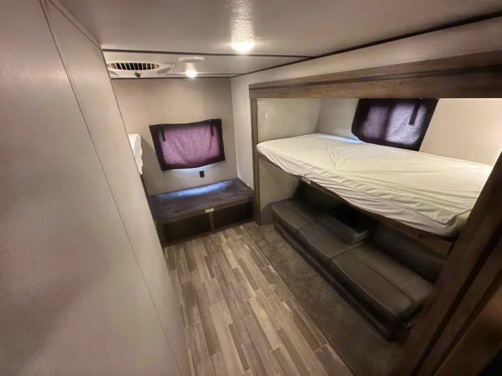 This RV rental features a cozy bunk bed over a sofa and an additional sleeping bench, perfect for family adventures.. Crossroads 328SB 2020