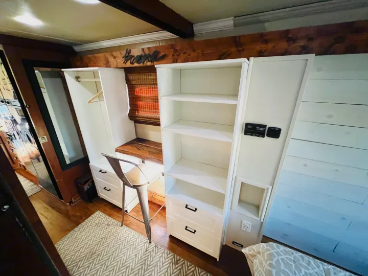Modern RV rental interior: custom white cabinets, shelving, an integrated desk, and warm wood accents.. Jayco Seneca 2013