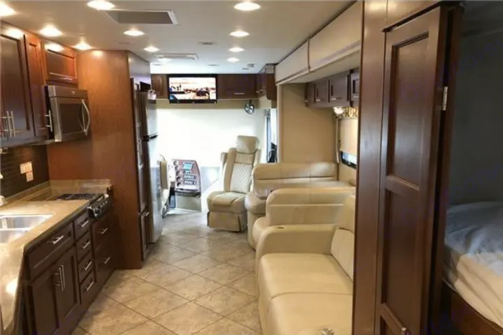 An inviting **rv rental** interior with a full kitchen, living space, and bedroom. Ideal for comfortable road trips.. Forest River Berkshire 2016