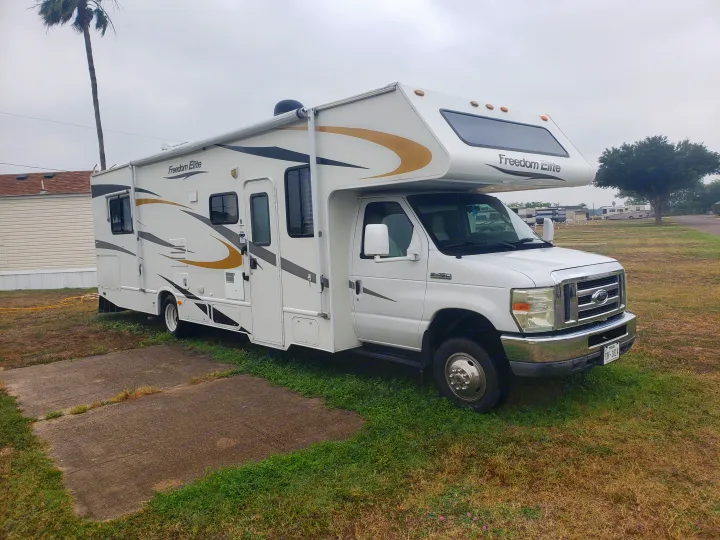 White Freedom Elite Class C rv rental motorhome parked at a Texas campground, ready for your next road trip adventure.. Four Winds Freedom Elite 2010