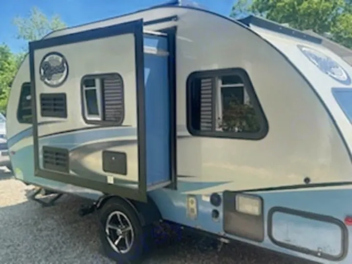 Compact light-colored travel trailer, ideal for RV rental. Features blue accents & a deployed pop-out, ready for camping trips.. R-Pod R-Pod Trailer 2018