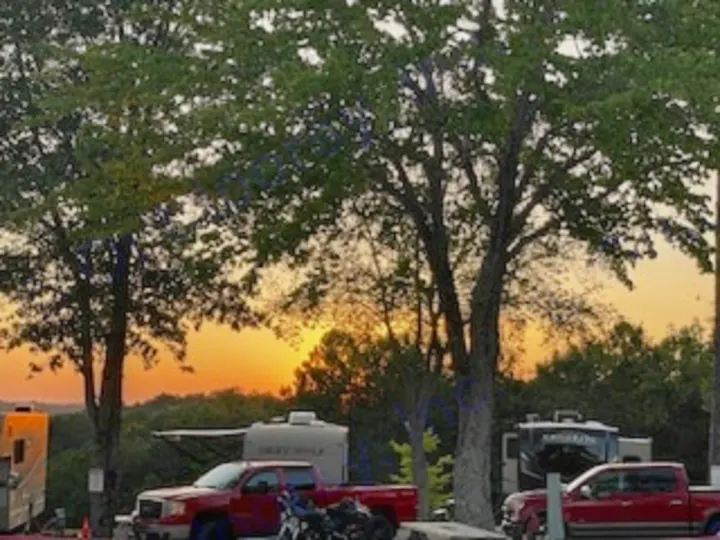 Vibrant sunset illuminates an RV campground with various RV rental units, trucks, & trees. Ideal for a camping getaway.. R-Pod R-Pod Trailer 2018