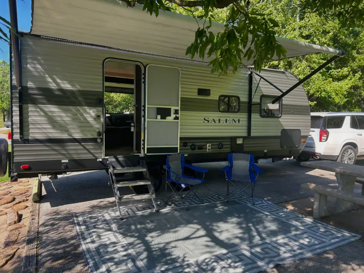 RV rental: Travel trailer with extended awning, outdoor chairs & patterned mat on pavement. Ready for a relaxing camp.. Forest River Salem 2020
