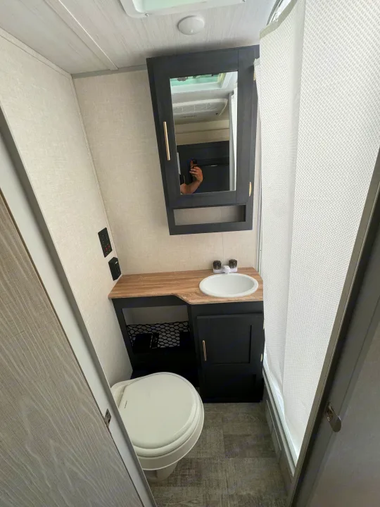 Compact RV bathroom with a toilet, vanity, sink, and shower area. Perfect for a convenient RV rental adventure.. R-Pod R-Pod Trailer 2024