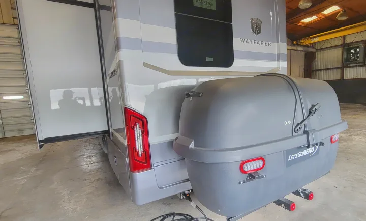 Rear view of an RV rental with an attached LetsGoAERO cargo box, ideal for transport and extra storage. Person's shadow visible.. Wayfarer Wayfarer Motorhome 2024