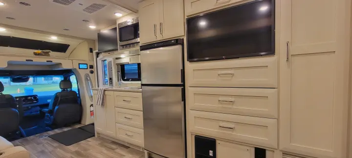 Explore this RV rental's inviting interior: sleek kitchen, entertainment zone, and spacious cockpit.. Wayfarer Wayfarer Motorhome 2024