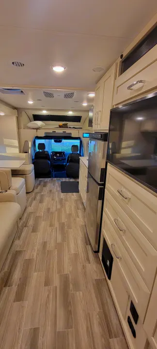 Spacious RV rental interior with a view of the cockpit, living area, and kitchen amenities.. Wayfarer Wayfarer Motorhome 2024