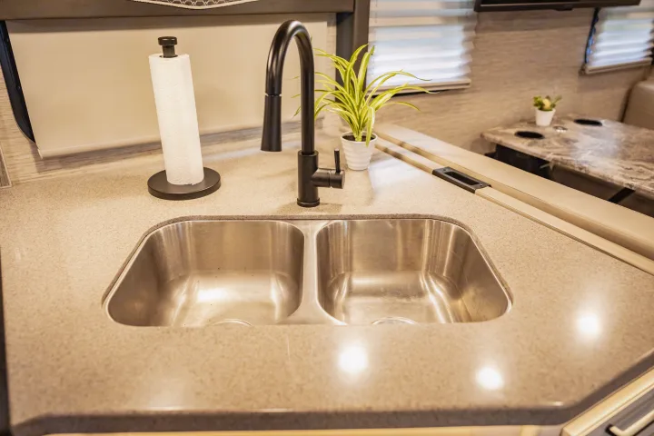 RV rental: a clean, modern kitchen features a double sink, black faucet, and paper towel holder.. Thor A.C.E. 2023