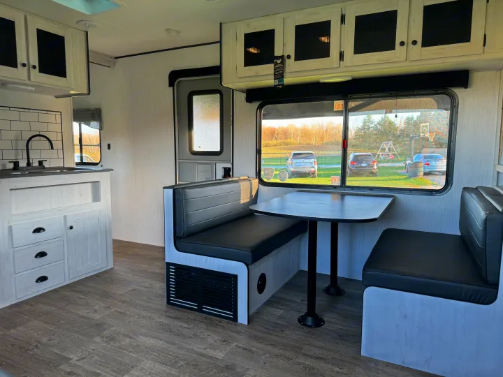 Modern RV rental interior featuring a bright kitchen, dinette, and comfortable seating. Ready for adventure!. Heartland RVs Trail Runner 2023