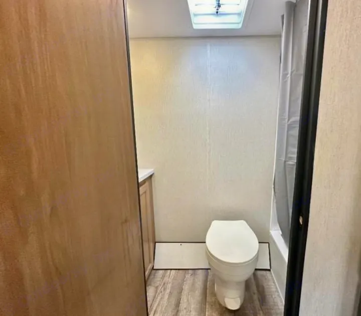 RV rental bathroom: compact design with toilet, shower, and vanity, typical of travel trailers.. Forest River Cherokee Wolf Pup 2023