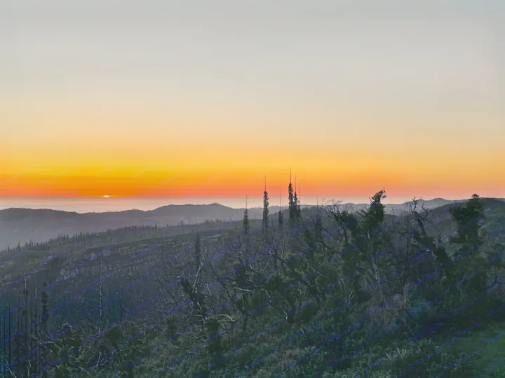 Golden sunset paints the sky above dark mountain silhouettes and distant fog. Explore these views with an RV rental!. Jayco Jay Flight SLX 2016