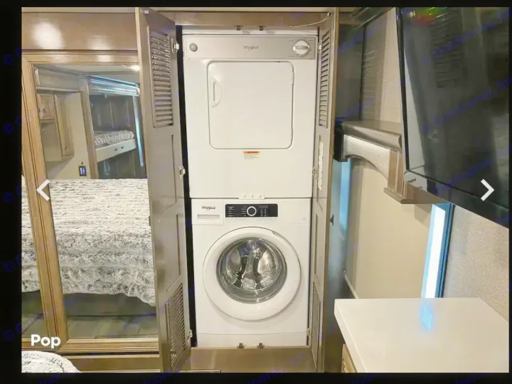 Compact stacked Whirlpool washer and dryer in this RV rental, providing convenient laundry solutions on the go.. Fleetwood Discovery LXE 2020