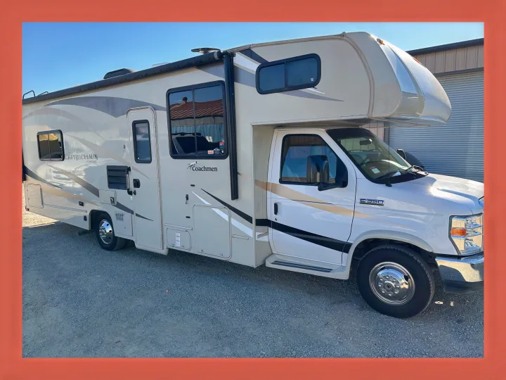 Experience freedom with this white and tan Class C Coachmen Leprechaun RV rental, parked on gravel, ready for your adventure.. Coachmen Leprechaun 2019