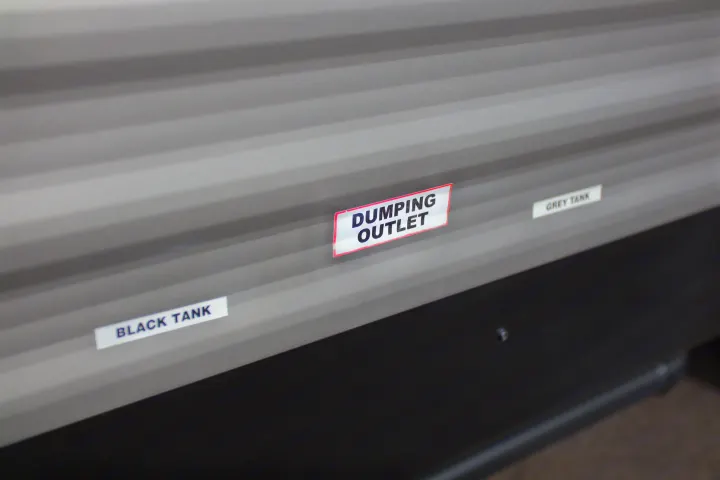 RV rental waste management: Clearly labeled black and grey tanks, plus dumping outlet, for easy RV maintenance.. Dutchmen Aspen Trail 2022