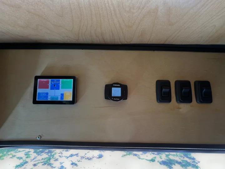 Inside an **rv rental**: Victron power monitor (100% battery, 27W solar), Webasto SmarTemp (77°F), & system switches.. Ford Transit 2023