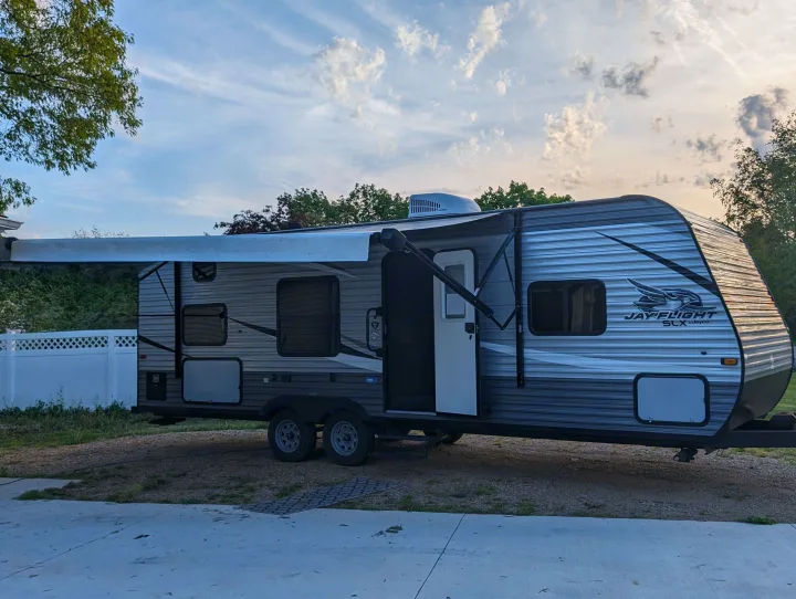 Grey Jayco travel trailer RV rental parked outdoors with awning extended, ready for adventures.. Jayco Jay Flight SLX 2021