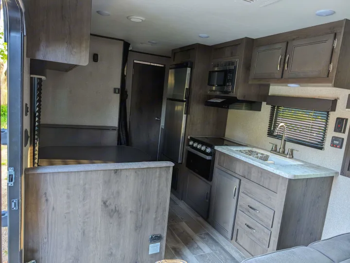 Inside this modern RV rental, find a full kitchen with fridge, stove, microwave, and sink, plus a comfy dinette.. Jayco Jay Flight SLX 2021