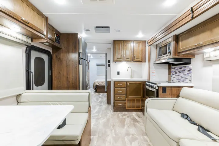 Spacious RV rental interior with full kitchen, dining booth, and sofa. Ideal for travel comfort and easy living on the road.. Gulf Stream Yellowstone 2023