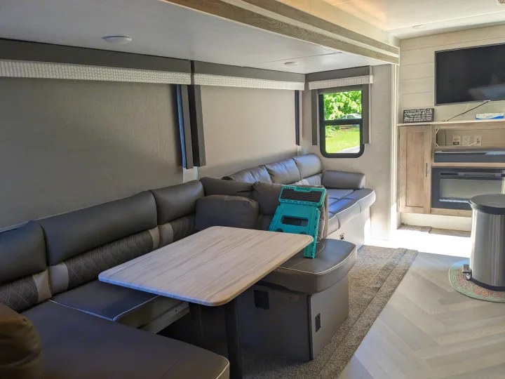 Modern RV rental living space with large U-shaped dinette, smart TV, and ample seating for your trip.. Forest River Wildwood 2021
