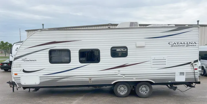 Side view of a white Coachmen Catalina travel trailer. Ideal for your next RV rental adventure, it features multiple windows.. Coachmen Catalina 2012